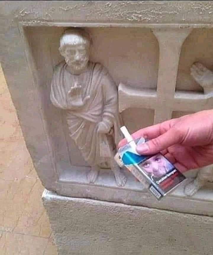 guy offering cigarettes to statue 