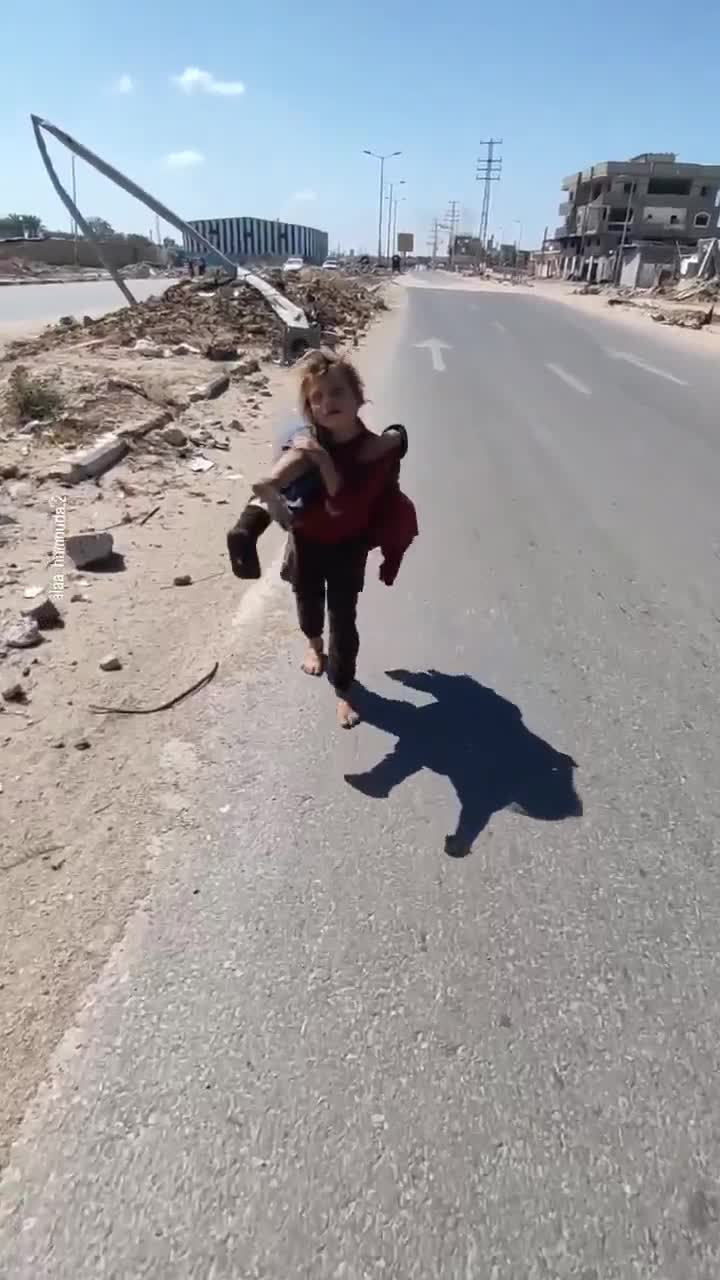 A young bare foot Palestinian child carries her sister for medical treatment everyday.
A Good Samaritan stops to help.