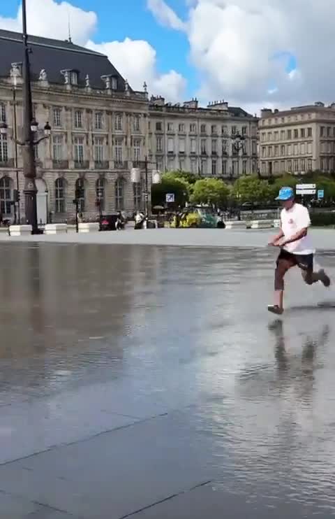 man slides on a street with surf board